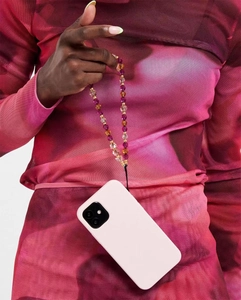 Close-up of a colorful beaded phone charm strap with purple and amber crystals on a pink case