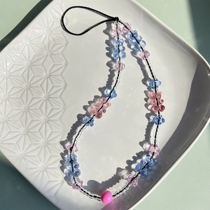 Close-up of pink and blue resin gummy bear beads on a beaded phone charm strap