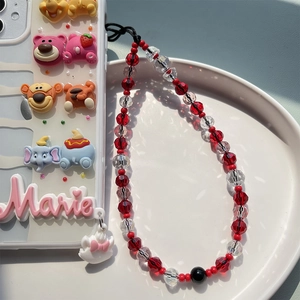 Detailed view of beaded phone strap with Disney characters and pink Marie charm