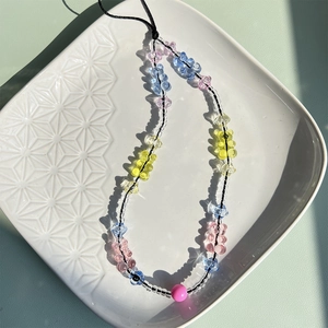 Close-up of colorful gummy bear beads and seed beads on a handmade phone charm strap