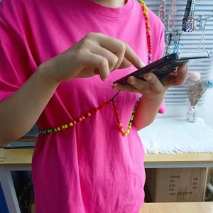 Colorful candy-colored bead crossbody phone strap with translucent crystals on model