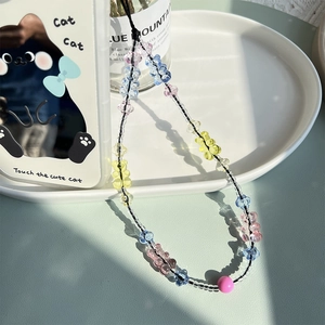 Detail of colorful gummy bear beads and small round beads on a handmade phone strap