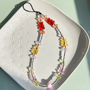 Close-up of colorful resin bear beads and rainbow charms on a ceramic tray display