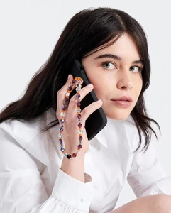 Colorful faceted crystal bead phone strap lanyard styled on a white shirt sleeve