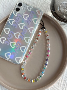Detail of holographic heart phone case with a rainbow crystal beaded charms lanyard