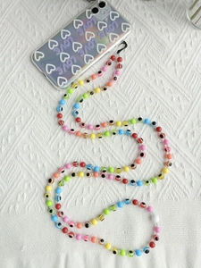 Detailed view of colorful rainbow beaded phone strap with evil eye charms on a phone case