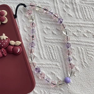 Colorful beaded phone strap with clear hearts and stars on vintage white knit background