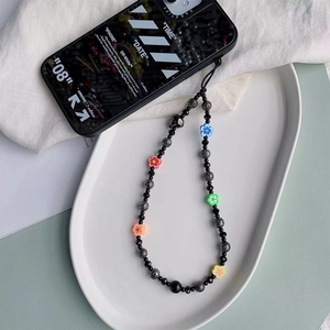 Detail of handmade beaded phone strap with skull beads and colorful flower charms