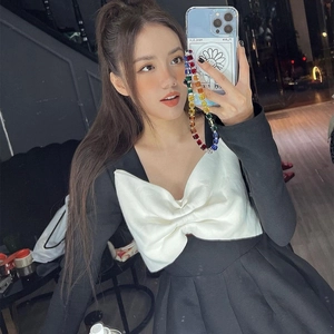 Women's A-line long sleeve dress in black and white with a large bow and colorful phone strap