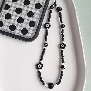 Minimalist black and white beaded flower phone strap with matte beads and glossy accents