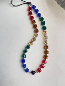 Detailed macro view of rainbow gradient square crystal beads with silver spacer accents