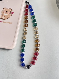 Macro shot of colorful crystal square beads with silver accents on a mobile phone lanyard