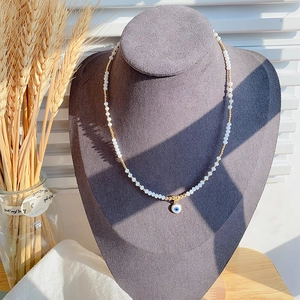 Detailopname van kralenketting met Evil Eye hanger op een sieraden display standaard