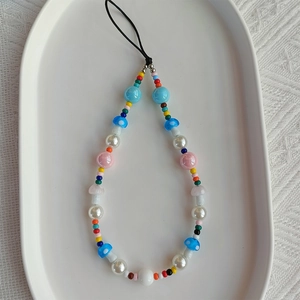 Detail of colorful bohemian phone strap with acrylic mushroom and faux pearl beads