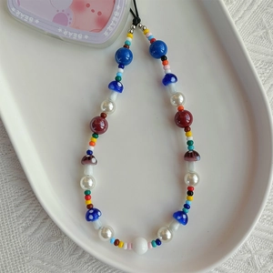 Detail of bohemian phone strap featuring colorful acrylic beads and 3D mushroom charms