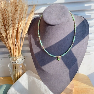 Detailopname van groene kralenketting met gouden accenten en een groene sterhanger