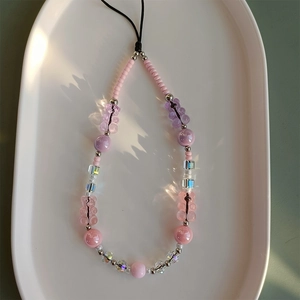 Detail view of colorful gummy bear beads and mixed acrylic spheres on phone lanyard strap