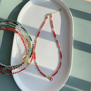Boho kristallen kralenkettingen met boze oog en hartjes op een decoratief dienblad