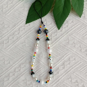 Detail of colorful beaded phone strap with acrylic pearls and mushroom charms