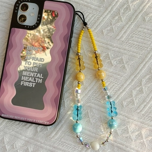 Detailed view of gummy bear beaded phone strap with purple wave texture mirror case