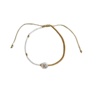 Handgemaakte witte kralen armband met gouden letter K en verstelbaar koordje