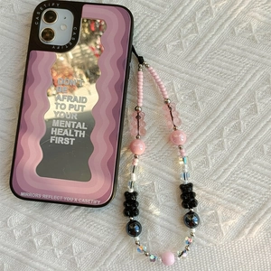 Detail of purple wavy mirror phone case with colorful gummy bear beaded wrist strap