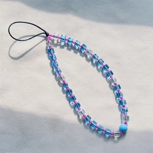 Handmade beaded phone strap featuring blue and transparent crystal beads on a grey surface
