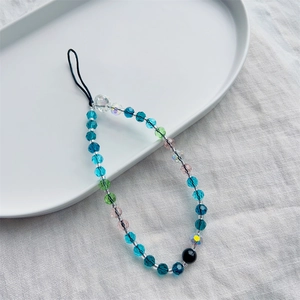Blue ocean themed crystal beaded phone charm with skull accent on a white tray
