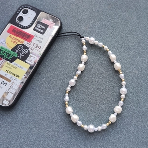 Detailed macro view of handmade pearl phone lanyard with baroque pearls and gold beads