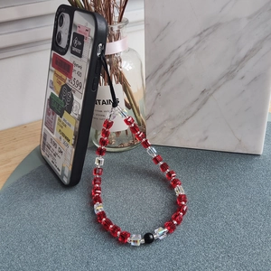 Handmade red crystal square bead phone strap with iridescent charms on a black case