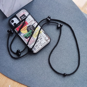 Handmade Y2K black seed bead phone strap with heart-shaped accents on gray background