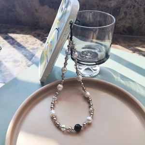Baroque pearl phone wrist strap with silver beads and crystals on a light green phone case