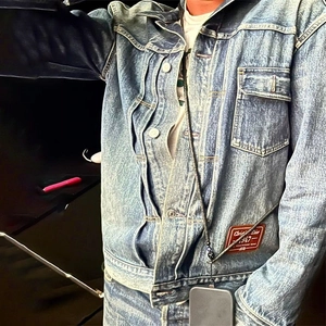 Detail of vintage blue denim jacket with signature woven label and classic metal buttons