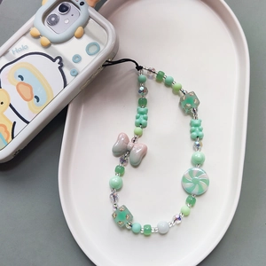 Beaded phone lanyard with mint green bow and bear charms on a white display tray