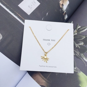 Detail of 18K gold starburst pendant necklace with zircon on a Thank You card
