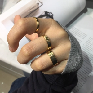 Three-piece set of polished gold rings in different widths worn by a model
