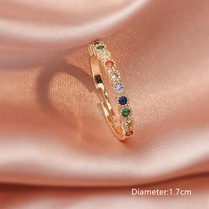 Verstellbarer goldener Ring mit bunten Zirkonia-Kristallen auf rosa Seide