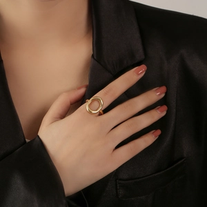 Bague ouverte ovale géométrique évidée dorée pour femme portée avec un blazer en soie