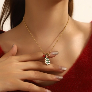 Close-up of a festive Christmas tree pendant with colorful enamel on a gold chain
