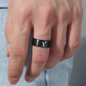 Primer plano de un anillo de acero inoxidable negro mate de 8mm con letra Y en el dedo