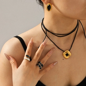 Retro gold and black enamel jewelry set with earrings, necklace, and stackable rings