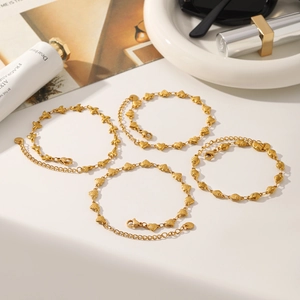 Macro view of gold-plated stainless steel heart chain bracelets set with lobster clasps