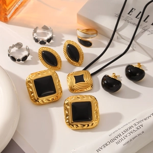 Close-up of vintage gold plated earrings and rings set with black enamel detail