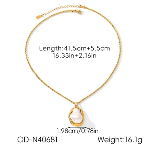 Dettaglio macro della collana a catena dorata con pendente in perla barocca su fondo bianco