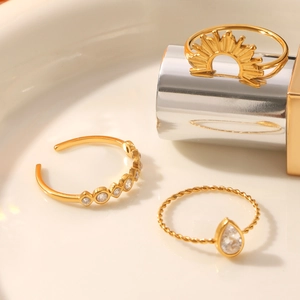 Detailed macro view of gold plated three-piece ring set with sunburst and droplet gems