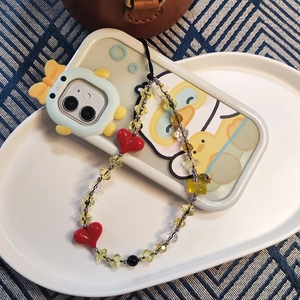 Detail view of a beaded phone strap with a cute yellow duck charm and heart beads