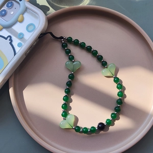 Close-up of green resin heart beads and woven wrist strap for phone case decoration