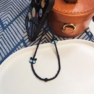 Cordon de téléphone perlé noir avec breloques chat bleues sur une coque décorée