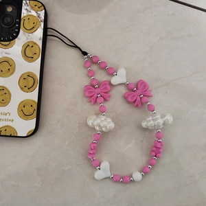Dettaglio del ciondolo per telefono in perline rosa con fiocco e cuore sulla cover