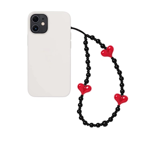 Minimalist black onyx bead phone strap with red heart charms on a white case